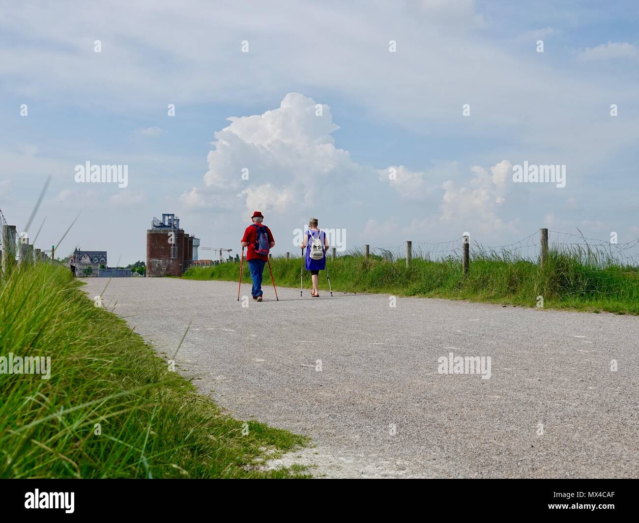 Paar mit Stöcken auf dem Weg zu einen Damm über die Somme, Picardie, Frankreich Stockfoto