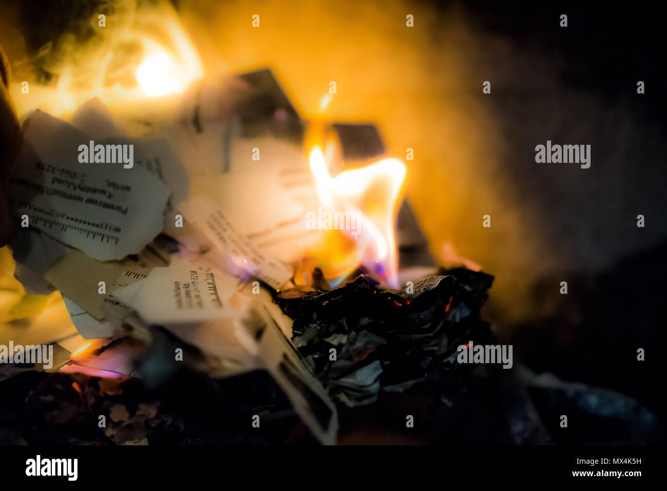 Brennendes Papier, Briefe, Dokumente mit Adresse, Name, persönliche Informationen in indoor Home Interior Kamin mit Nahaufnahme von orange, blaue Flamme Stockfoto