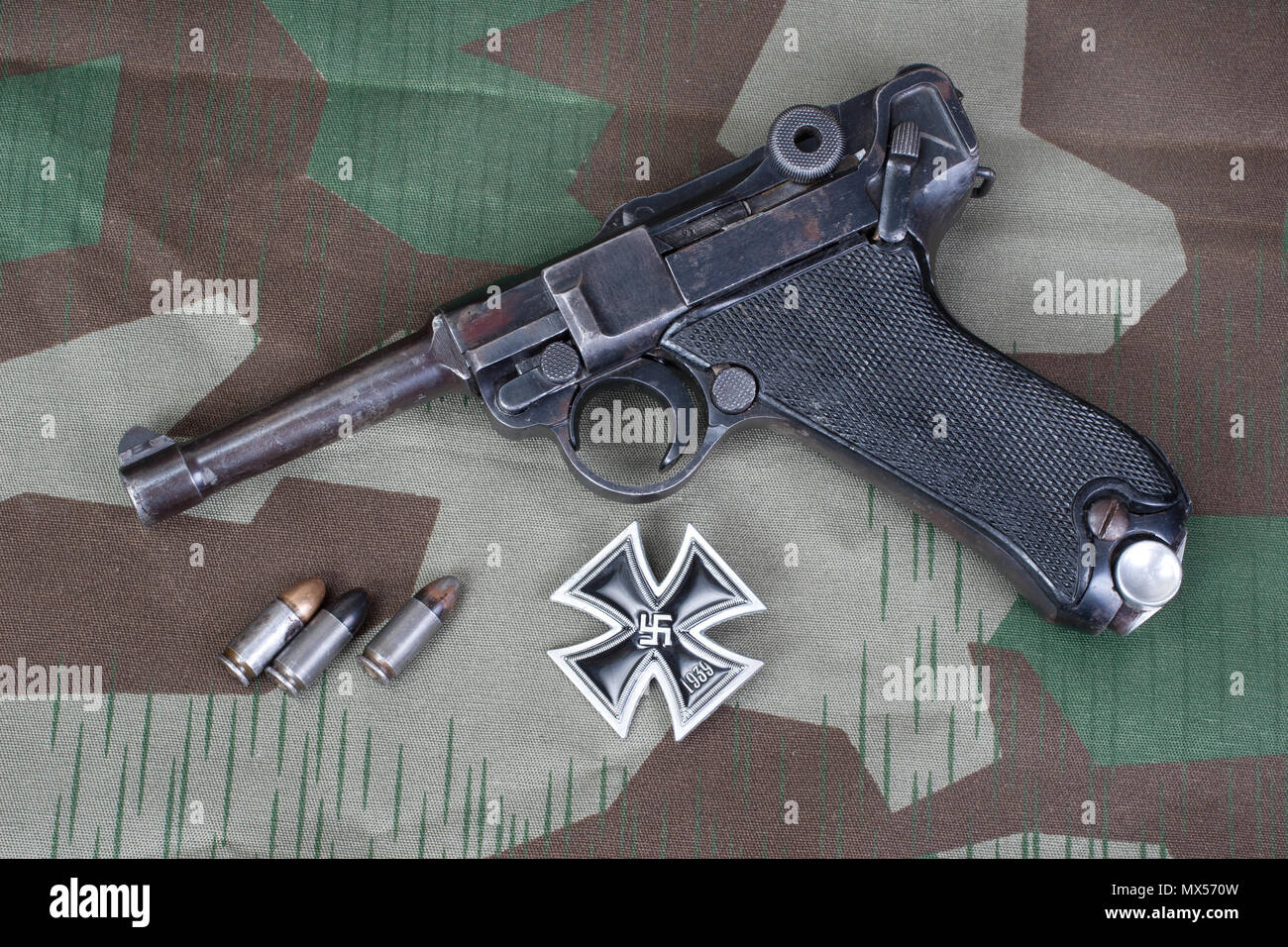 Parabellum Pistole, Munition und Medaille Eisernes Kreuz auf getarnte Hintergrund Stockfoto