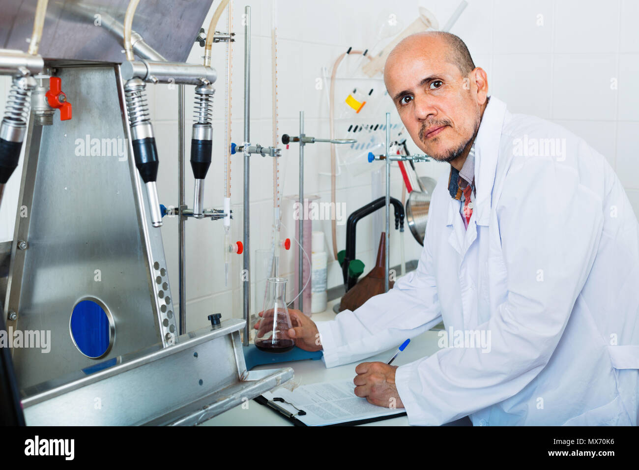 Aufmerksame reifer Mann arbeiten im Hinblick auf die Qualität der Produkte im Weingut lab Stockfoto
