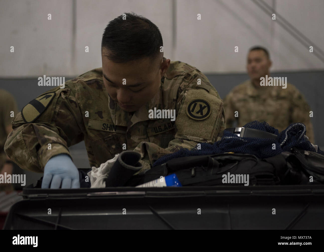 Us-Armee SPC. Jong Wook Shin, 368 Militärpolizei Unternehmen, prüft den Inhalt eines Stück Gepäck am Flughafen Bagram, Afghanistan, 30. April 2017. Bei ihren Inspektionen der Zoll Team folgt strengen Richtlinien von mehreren staatlichen Stellen die US-Zoll- und Grenzschutzbehörde, US-Landwirtschaftsministerium und dem Präsidium von Alkohol, Tabak, Schusswaffen und Sprengstoffe, wenn durch Gepäck Suche zu gehören. Stockfoto