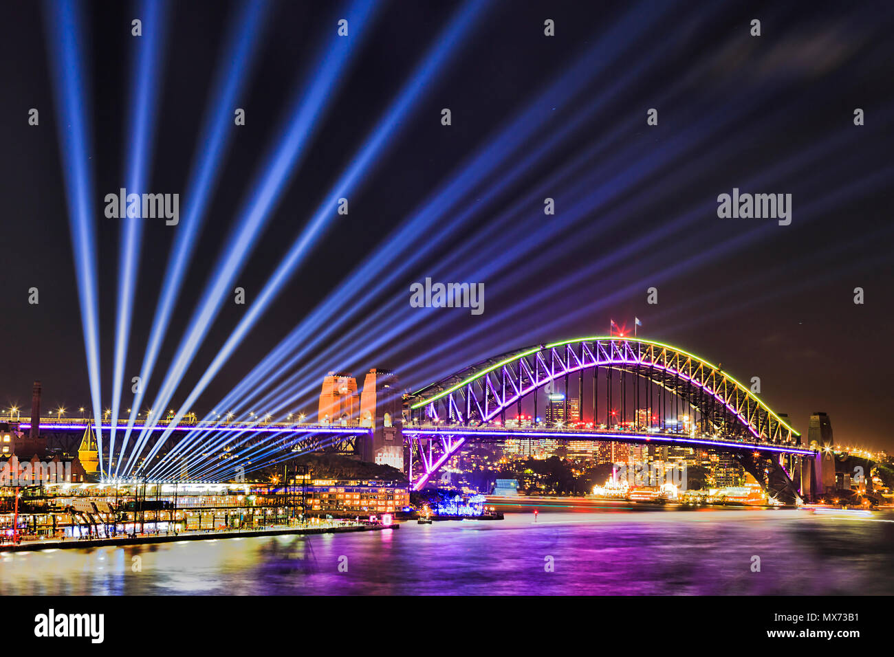 Vivid Sydney Festival des Lichts und der Ideen in der Stadt Sydney CBD um Hafen mit Lichtstrahlen aus der Harbour Bridge vom Circular Quay. Stockfoto