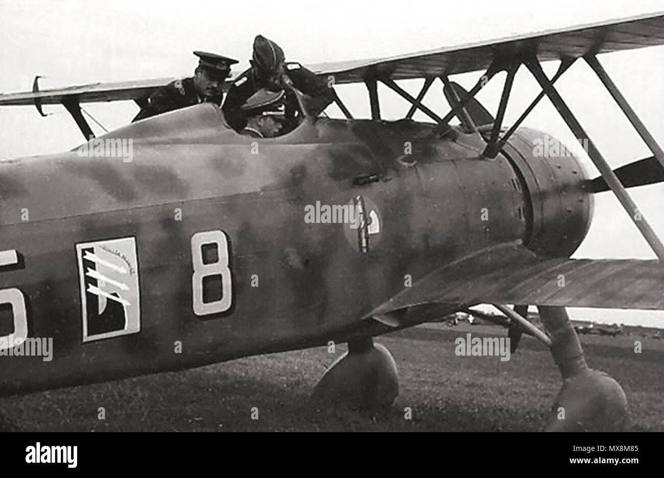 . Englisch: Ein deutscher Offizier im Cockpit sitzen untersucht das Bedienfeld eines Fiat CR.42 'Falco' der 85. Staffel, XVIII Gruppe C.T. (Terrestrische Fighter Group), 56th Wing C.T., italienische Luft Corp, die Schlacht um England, Belgien 1940. 1940. Unbekannt 208 Fiat CR.42 - Belgien Stockfoto