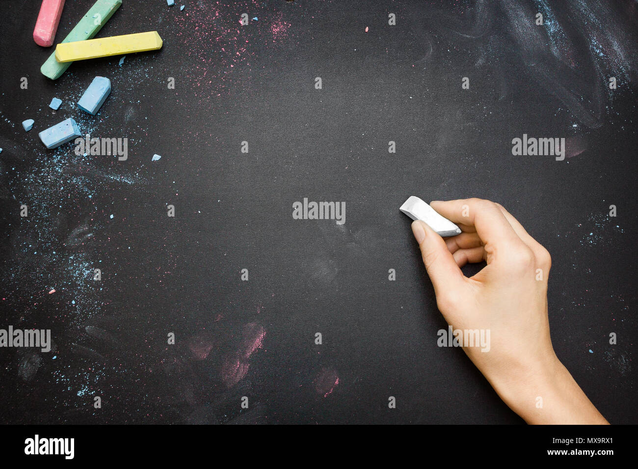 Weibliche Hand schreiben auf einer Tafel der Tischplatte mit weißer Kreide Stockfoto