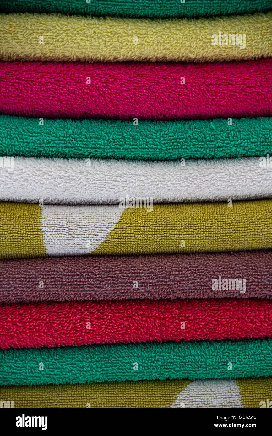 Bunte Handtücher übereinander gestapelt. Gestapelte handtücher Hintergrund. Der Service im Hotel und Urlaub Konzept. Stockfoto