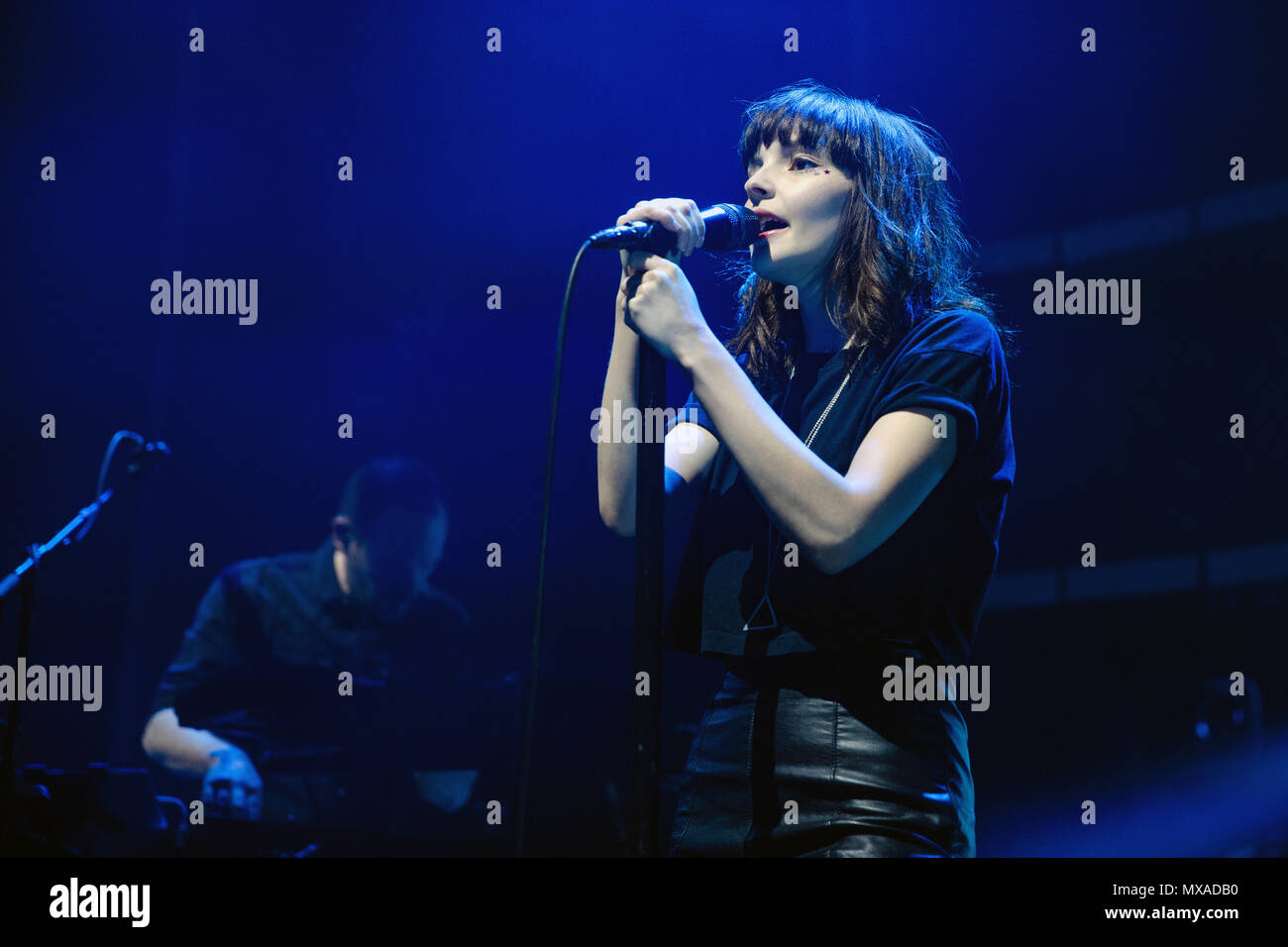 Lauren Mayberry von CHVRCHES live auf der Bühne während der Jedes offene Auge tour. Im Hintergrund ist ihr Bandmitglied Iain Cook. Lauren Mayberry live, Lauren Mayberry Sänger, Sängerin, CHVRCHES CHVRCHES band, CHVRCHES in Concert. Stockfoto