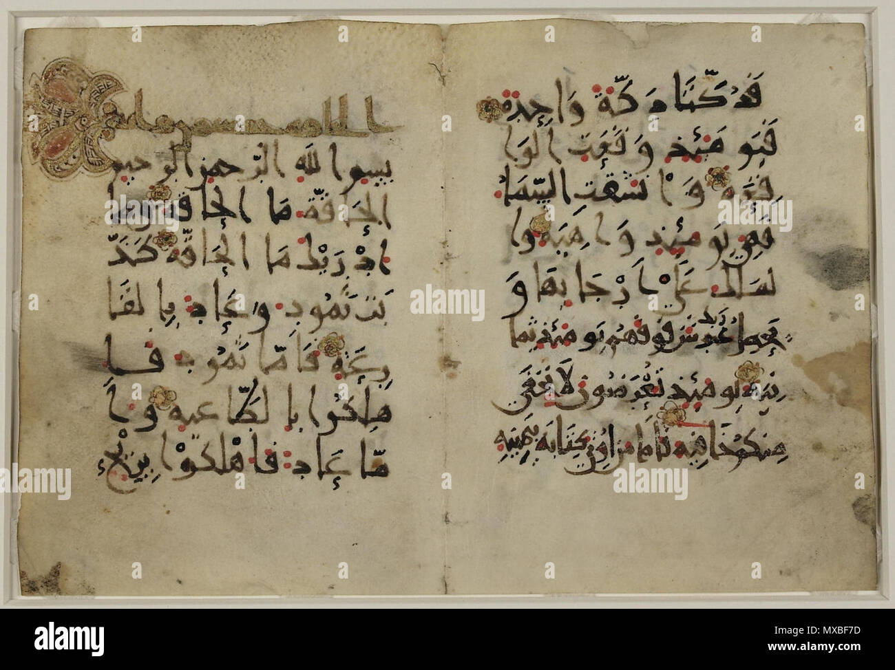 . Englisch: Diese Kalligrafischen Fragment enthält, auf der linken Seite des bifolio, die beleuchteten Titel und die Verse 1-6 des 69. Kapitel des Qur'an al-Haqqah (die Wahrheit). Der Text ist in Kufi (Neue BUPET III) geschrieben. Rote Punkte zeigen Vokalisierung, während Vokal Zeichen und orthoepics (Aussprache) in schwarzer Tinte zu einem späteren Zeitpunkt hinzugefügt wurden. Ein Punkt unter dem Buchstaben ra (r) dient, um ihn aus der zayn (z) unterscheiden. Das Skript, Vokalisation und vertikales Format zeigen einige der Fortschritte in der Kufi Kalligraphie und Koran Produktion während des 10. Jahrhunderts. 10. Jahrhundert. Un Stockfoto