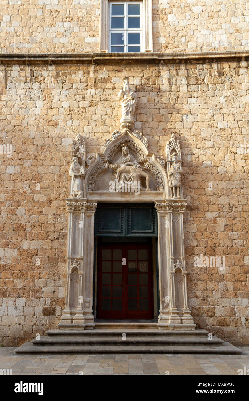 Reich verzierte Eingangstür zum Franziskanerkloster auf Stradun in der Altstadt von Dubrovnik, Kroatien. Stockfoto