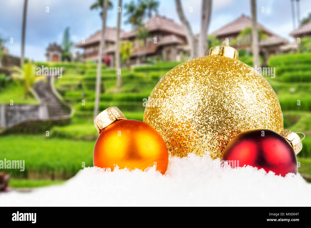Thema Weihnachten mit balinesischen Dorf unscharfen Hintergrund, balinesische Architektur in den Hintergrund und die drei bunten Weihnachtskugeln in der Front Stockfoto