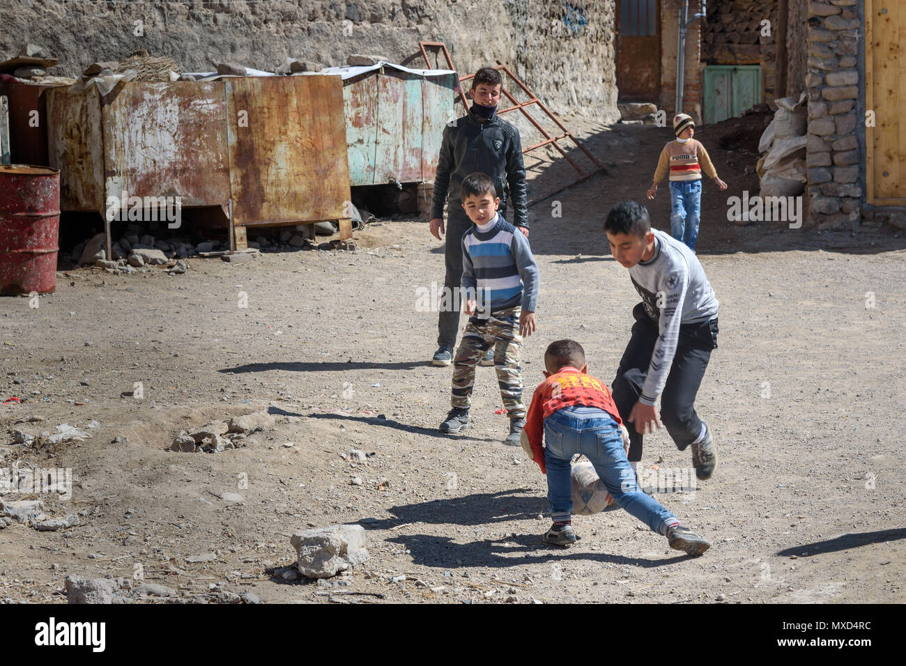 Kandovan, Osten der Provinz Aserbaidschan, Iran - 16. März 2018: TYoung iranischen Jungen Fußball spielen auf der Straße in Rock Dorf Kandovan Stockfoto