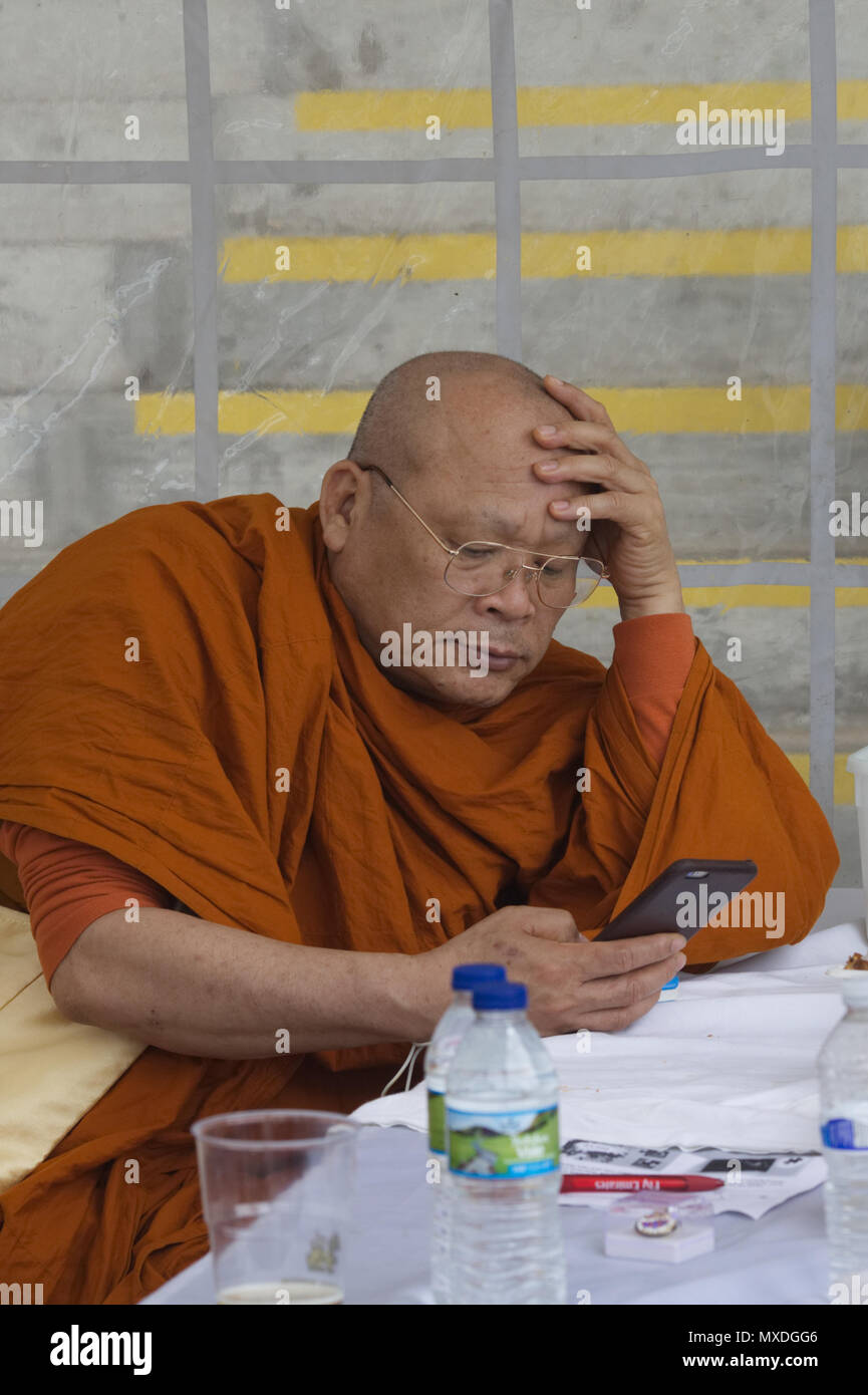 Buddhistischer Mönch auf seinem Mobiltelefon Stockfoto