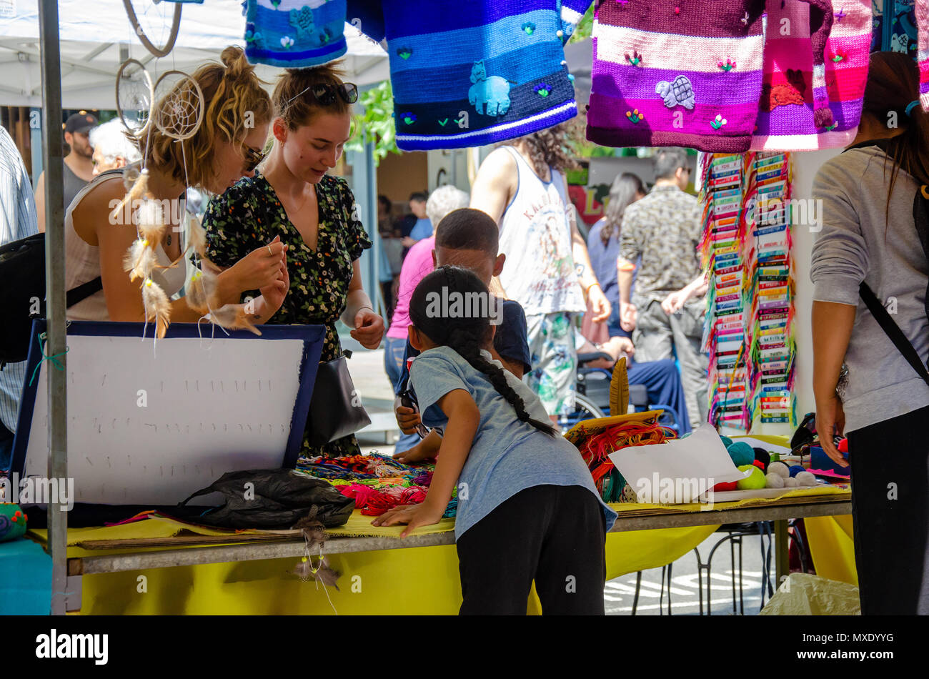 Ein Mädchen hilft, ihre Mutter auf einem Marktstand verkaufen Schmuck.. Stockfoto