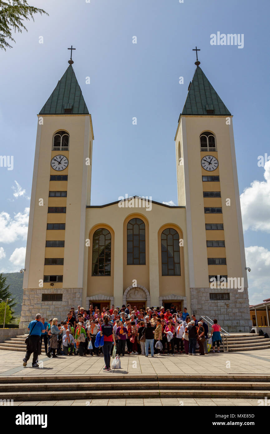 Eine Pilgergruppe posieren für ein Foto vor der Kirche des Hl. Jakobus in Medjugorje (oder Medjugorje), Föderation von Bosnien und Herzegowina. Stockfoto