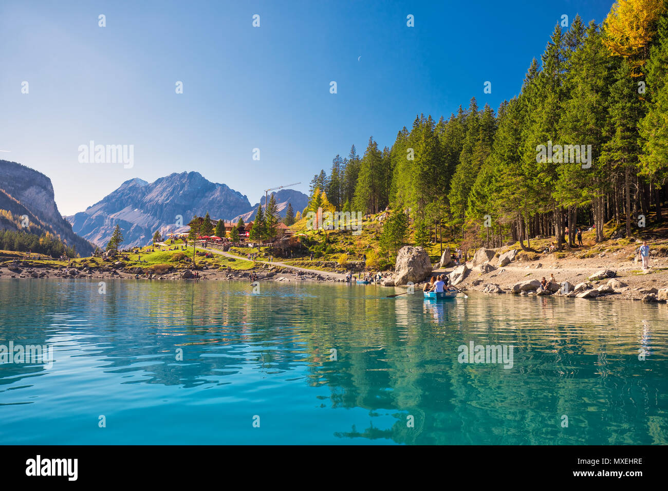 OESCHINENSEE, SCHWEIZ - Oktober 2017 - Amazing tourquise Oeschinnensee mit Wasserfällen, Chalet aus Holz und Schweizer Alpen, Berner Oberland, Schweiz Stockfoto