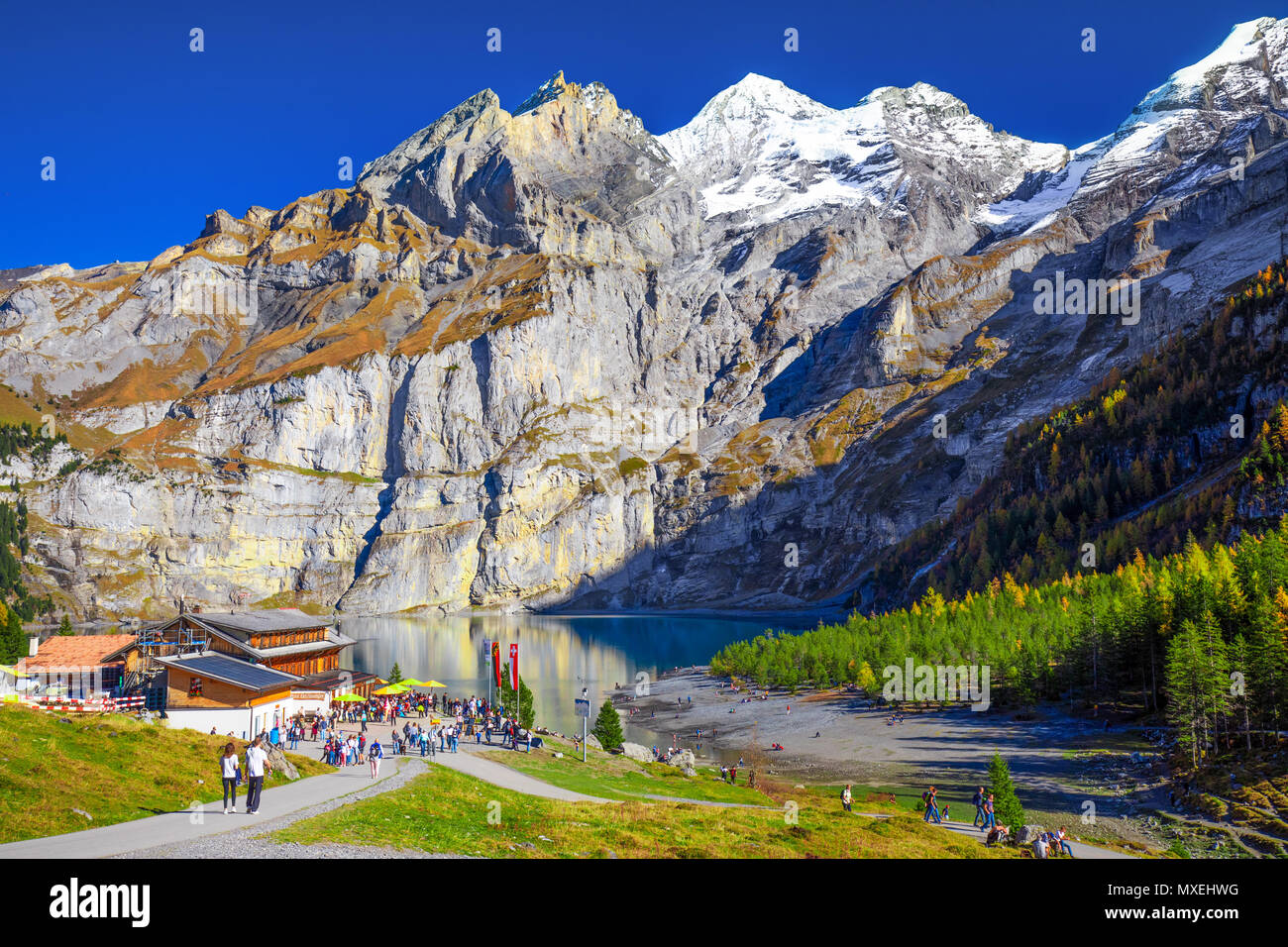 OESCHINENSEE, SCHWEIZ - Oktober 2017 - Amazing tourquise Oeschinnensee mit Wasserfällen, Chalet aus Holz und Schweizer Alpen, Berner Oberland, Schweiz Stockfoto