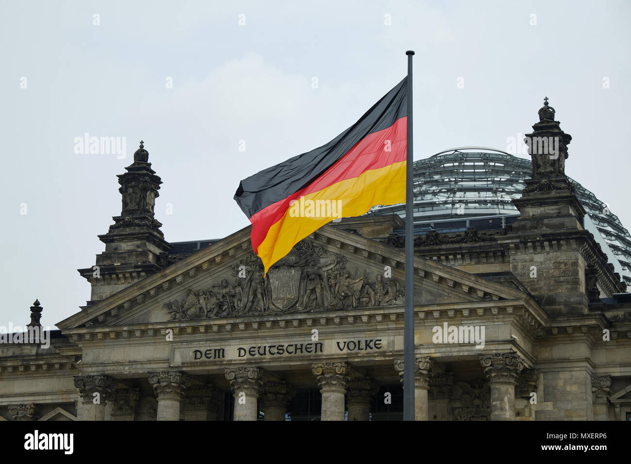 Berlin, Deutschland - 14 April 2018: Giebel mit Spalten und Kuppel des Reichstagsgebäudes mit Deutschen Einheit Flagge im Vordergrund Stockfoto