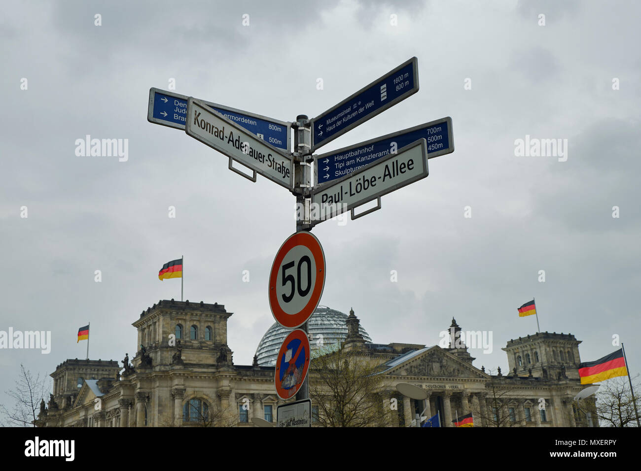 Berlin, Deutschland - 14 April 2018: Street Wegweiser den Weg zu den Sehenswürdigkeiten und Reichstag mit deutschen Fahnen auf dem Hintergrund unter der du Stockfoto