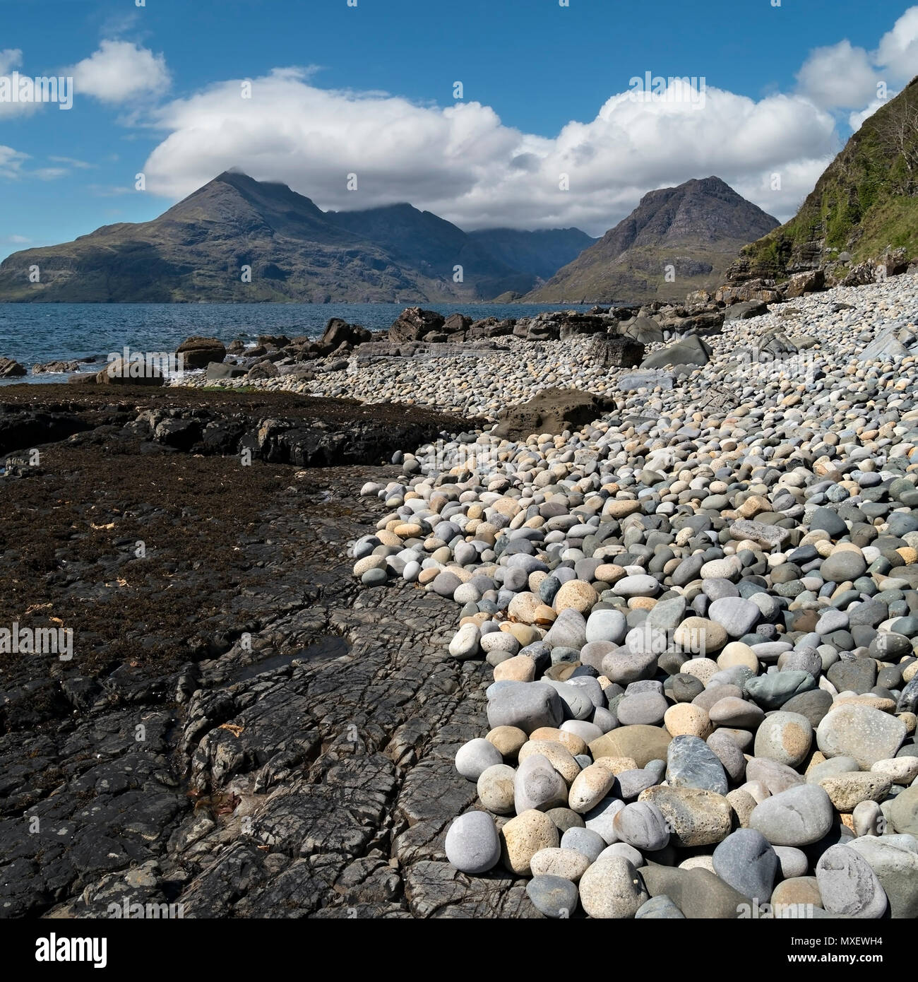 Steine und Felsen von Glen Scaladal Bay (Cladach ein ghlinne) in der Nähe von Elgol, mit Meer und Black Cuillin Berge, Isle of Skye, Schottland, Großbritannien Stockfoto
