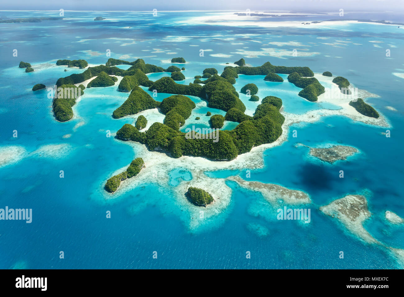 Luftaufnahme von bunten Mustern und Designs von Korallenriffen und winzige Tropfen und Ringe von grünen Inseln Stockfoto
