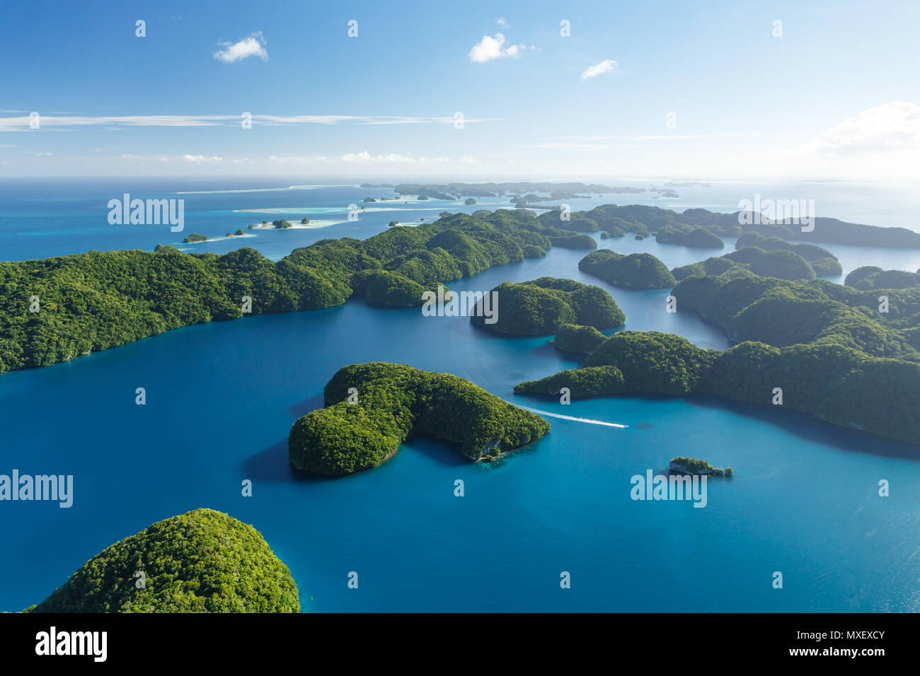 Luftaufnahme von Boot in Korallenriffen reisen, Korallenatolle und zwei kleinen Inseln umgeben vom türkisblauen Wasser des Südpazifik Stockfoto