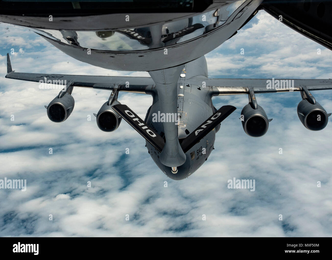 Eine C-17 Globemaster III mit dem 445Th Airlift Wing an Wright-Patterson Air Force Base, Ohio fliegen in Richtung einer KC-135 Stratotanker mit Die 121 Luftbetankung Wing an Rickenbacker Air National Guard Base, Ohio in den Himmel über Ohio 31. Mai 2018. Die C-17 wurde später von der Stratotanker aufgetankt. (U.S. Air National Guard Foto von Airman 1st Class Tiffany A. Emery) Stockfoto