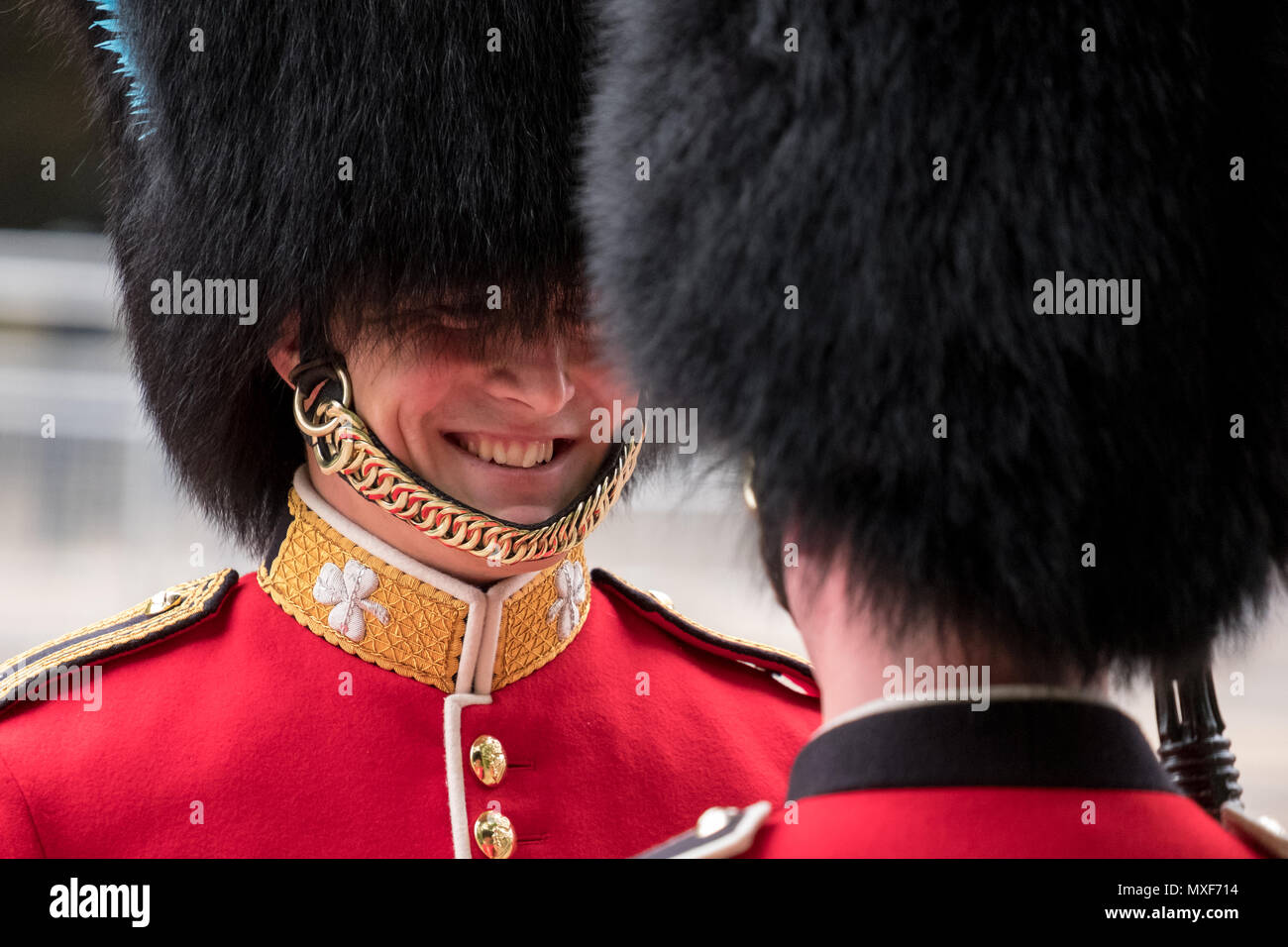 Royal Guard Soldaten das Tragen der roten und schwarzen Uniform und bärenfellmütze Hüte Sharing ein Witz während der die Farbe militärische Parade, London UK Stockfoto