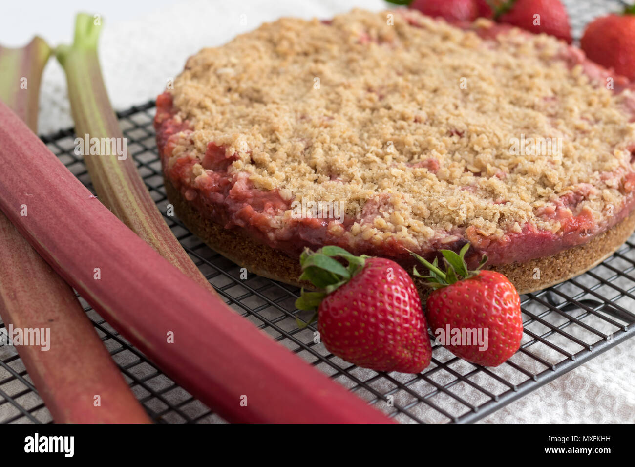 Eine köstliche Erdbeeren und Rhabarber crumble Slices, mit frischem Obst angezeigt. Hausgemachte und noch warm aus dem Ofen. Dieses Rezept ist glutenfrei. Stockfoto