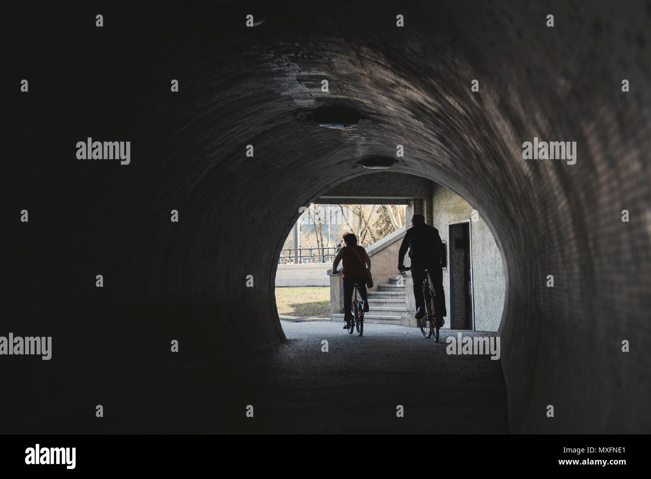 Silhouette Radfahrer in Hintergrundbeleuchtung aus einem Tunnel, einer alten Stadt Stockfoto