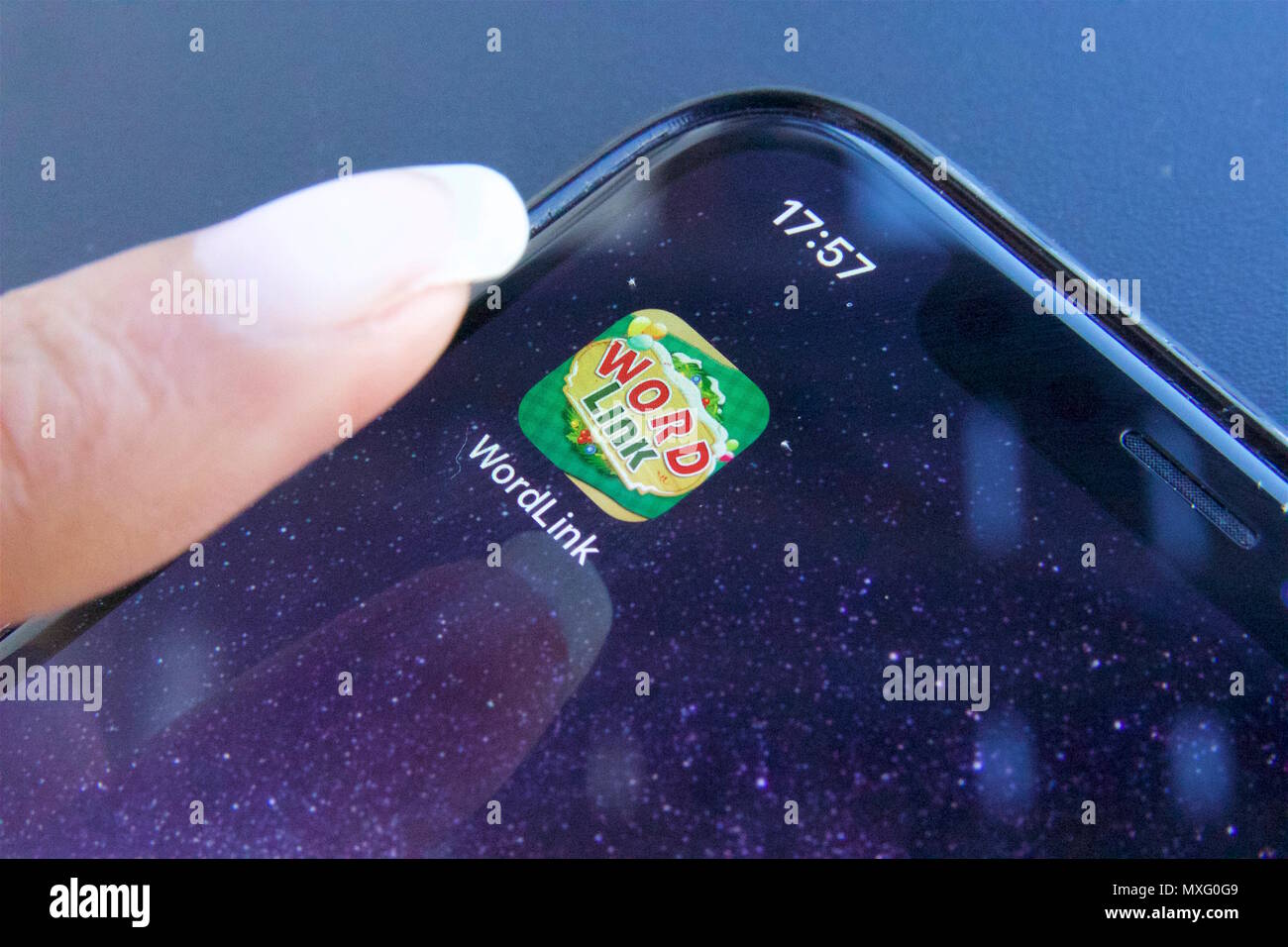 Eine Person, die die Rolle des beliebten mobilen Spiel app WordLink, das ist ein Wort, das Spiel, auf einem iPhone X Stockfoto