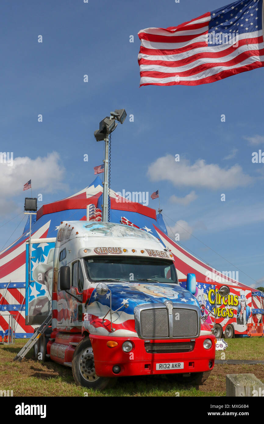 Eine bunte amerikanische Lkw für Zirkus mit dem Zirkus bigtop Vegas, ein touring Circus verwendet, im Hintergrund. Stockfoto