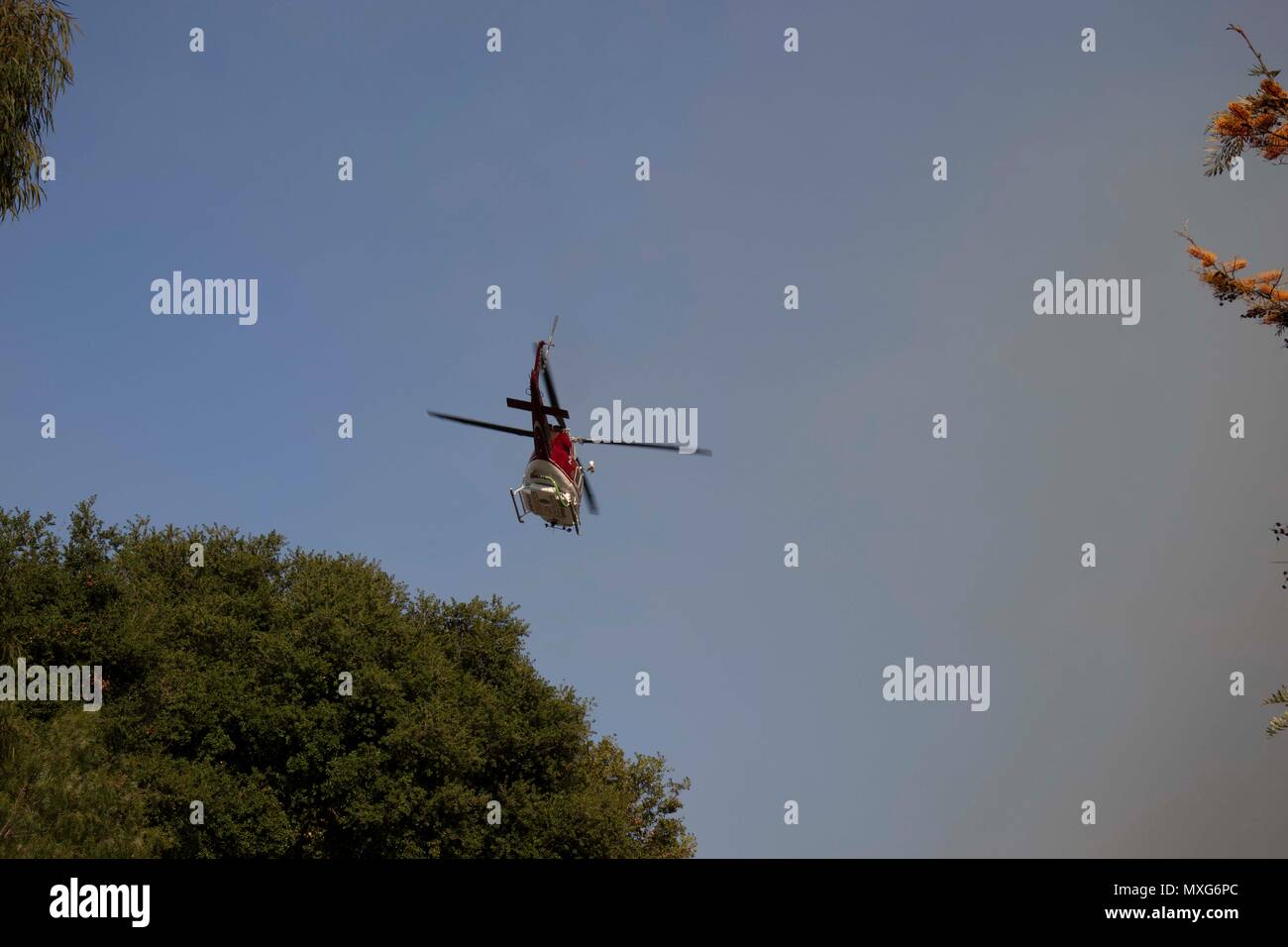 Feuerwehr Hubschrauber fliegen in Aktion eine aktive Flamme zu kämpfen Stockfoto