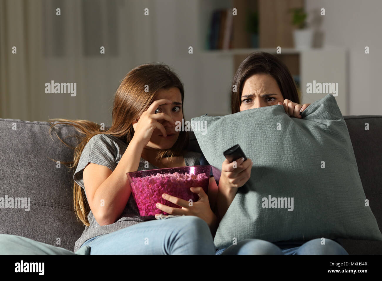 Angst Freunde tv in der Nacht auf einer Couch im Wohnzimmer zu Hause sitzen beobachten Stockfoto