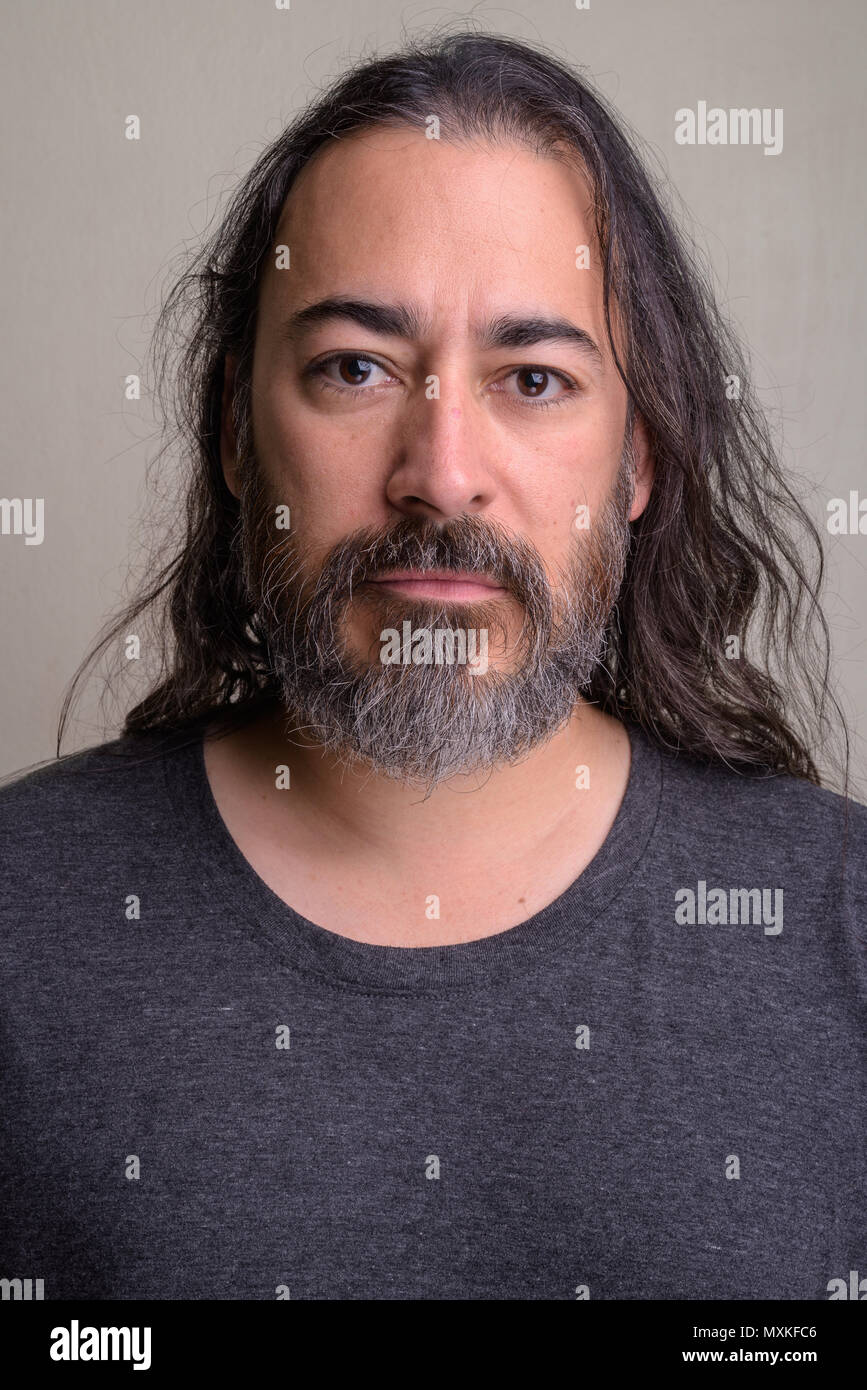 Studio shot der Reifen gut aussehenden Bärtigen multi-ethnischen Mann mit dem langen Haar Stockfoto