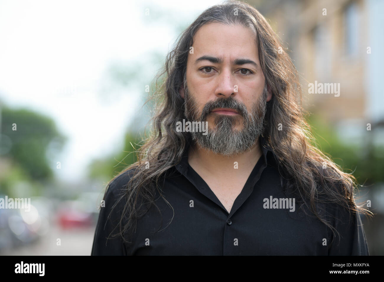 Reifen gut aussehenden Bärtigen multi-ethnischen Geschäftsmann mit langen Haaren in den Straßen im Außenbereich Stockfoto