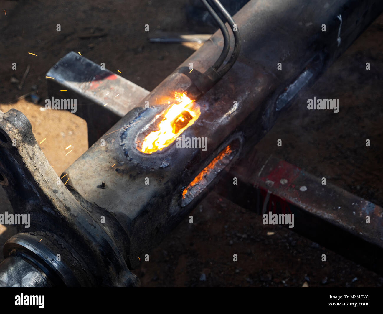 Metall arbeiten. Man schneidet ein Loch in einen Stahl Stück mit gas schweißen Stockfoto