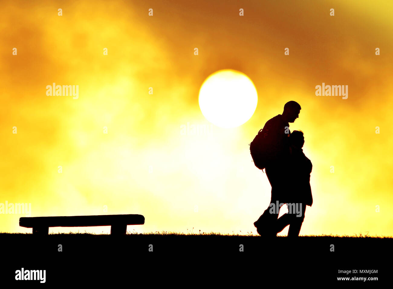 Paar homeward bei Sonnenuntergang gebunden Stockfoto