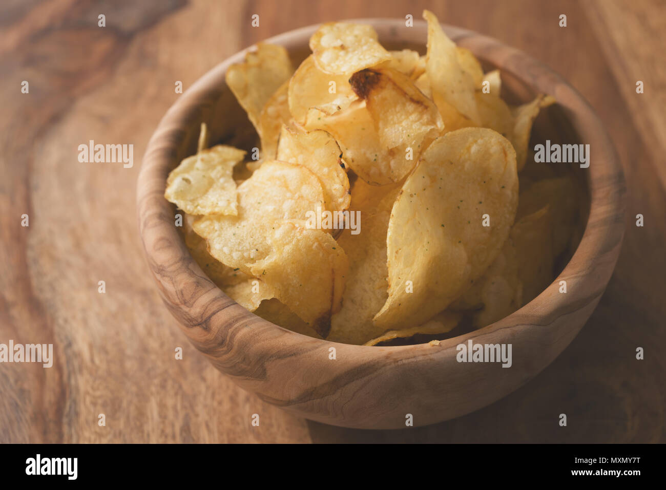 Bio Kartoffelchips mit Kräutern in Schüssel auf Holz Tisch Stockfoto