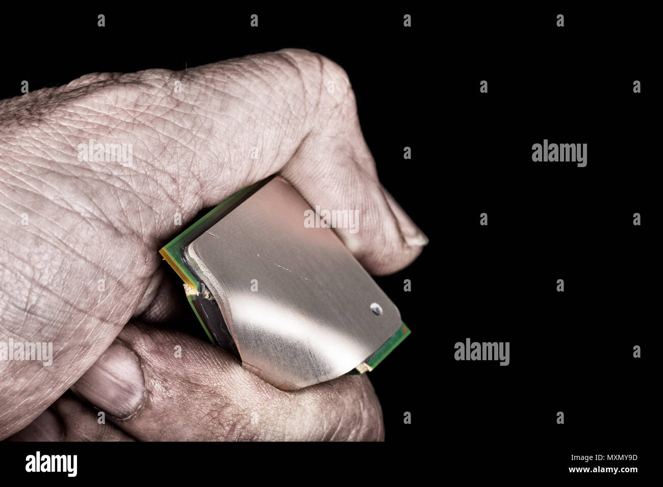 Schmutzige hand bricht Mikroprozessor mit kritischen Fehler. Zerstört computer Prozessor in der saboteur Finger auf schwarzem Hintergrund. Idee der Cybersicherheit. Stockfoto