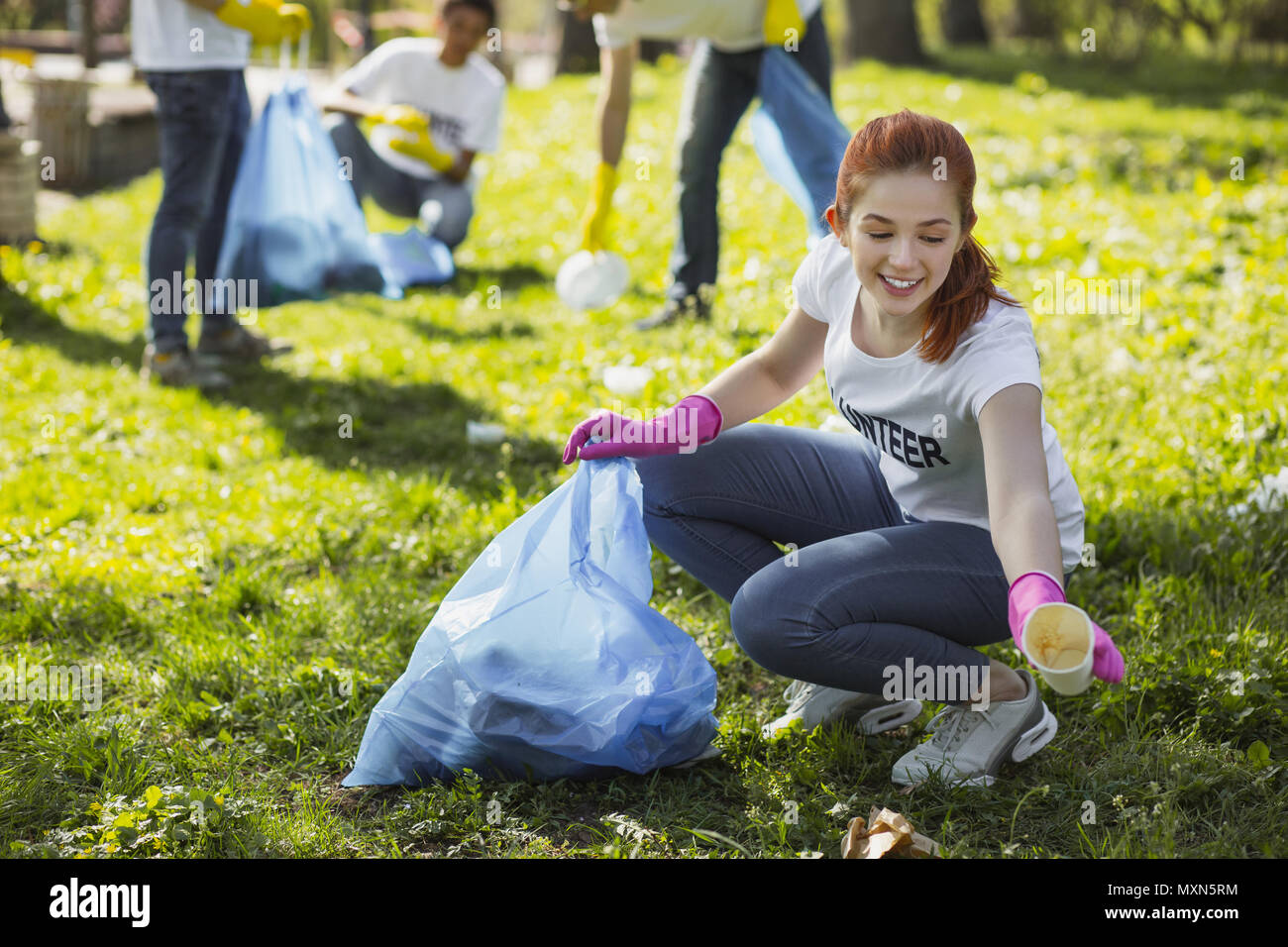 Jolly weibliche ehrenamtliche Pflege der Natur Stockfoto