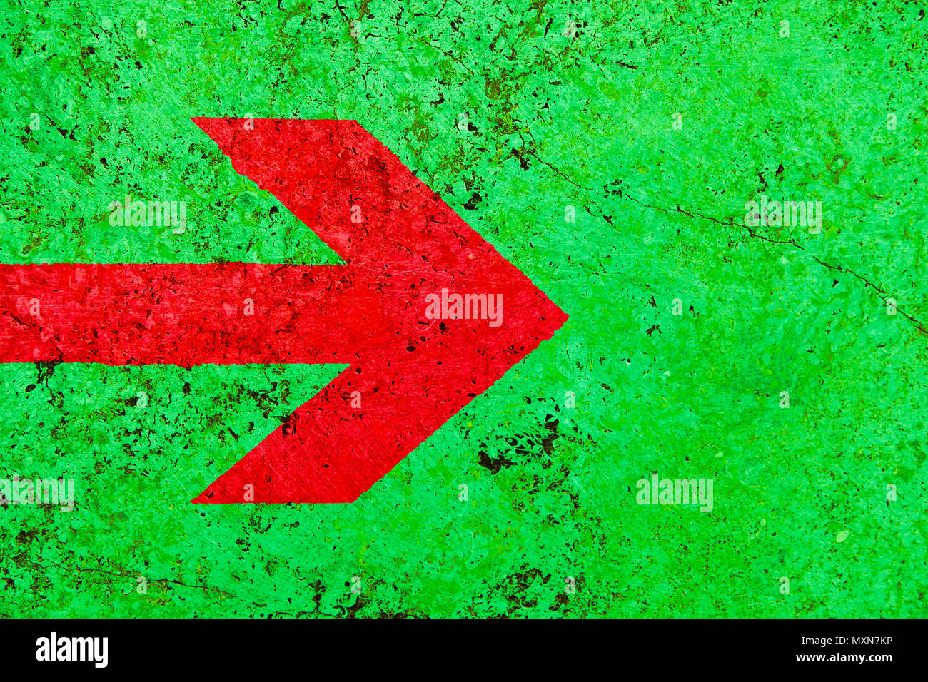 Roter Pfeil Richtung Schild über lebendige helle grüne Farbe stone wall mit Unebenheiten und Risse als leere rustikal und einfach Hintergrund Textur Raum Stockfoto