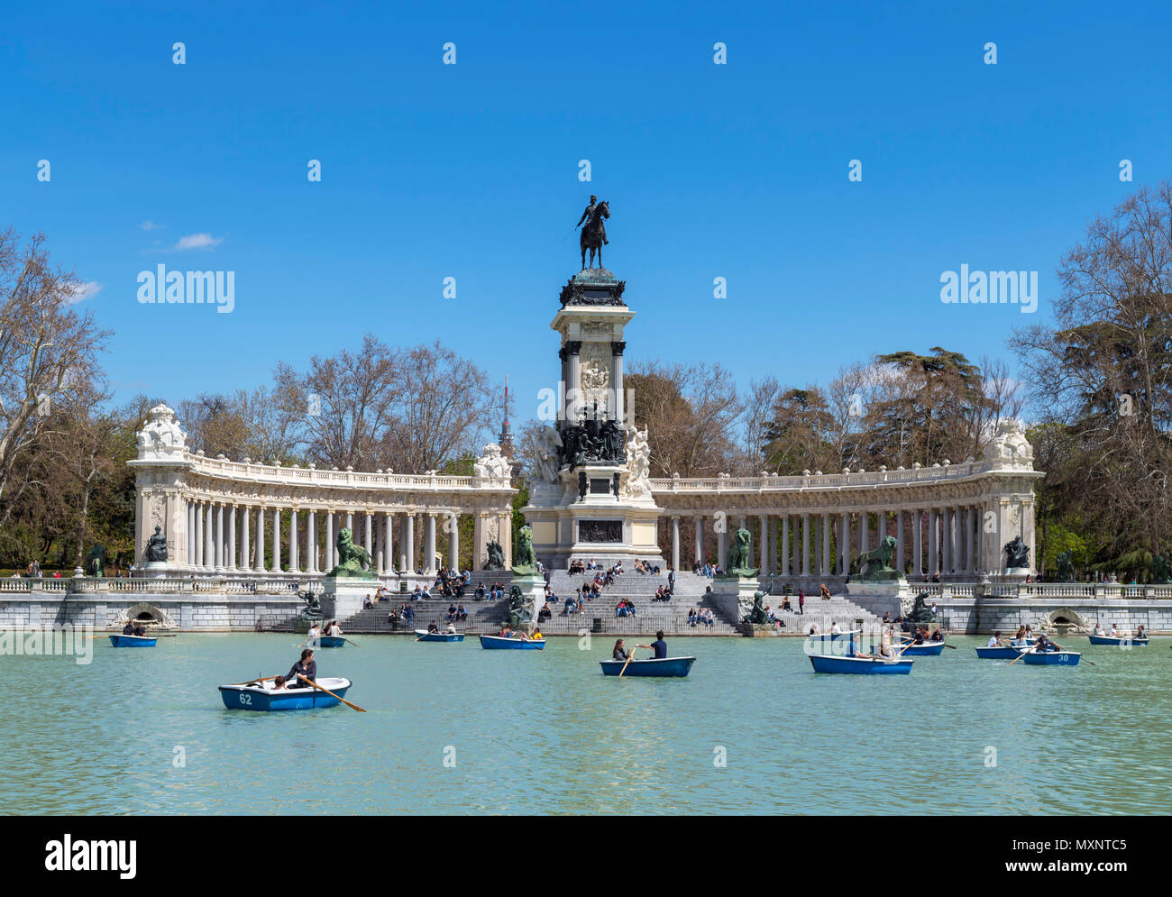 Madrid, El Retiro Park. Bootfahren auf dem estanque Grande del Retiro mit der Alfonso XII Denkmal hinter, Parque del Buen Retiro, Madrid, Spanien. Stockfoto