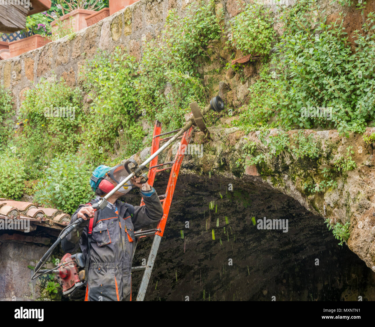 Tuscania (Viterbo), Italien - 2. Mai 2018: die städtischen Gärtner mit STRIMMER in einer archäologischen Stätte in Tuscania, Italien Stockfoto