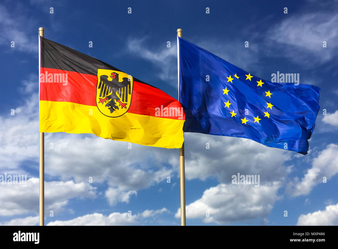 Flaggen von Deutschland (Bundesrepublik Deutschland; in Deutscher Sprache: Bundesrepublik Deutschland) und der Europäischen Union (EU) im Wind auf einem hellen, sonnigen Stockfoto