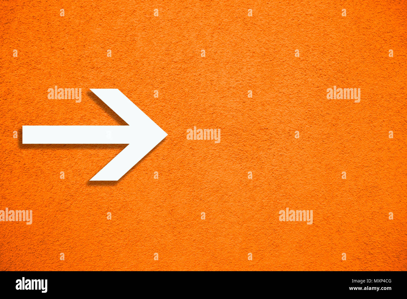 Weißer Pfeil Richtung Schild über Vivid hell orange Farbe Stuck raue Wand als leere rustikal und einfach Hintergrund Textur mit leeren Raum. Stockfoto