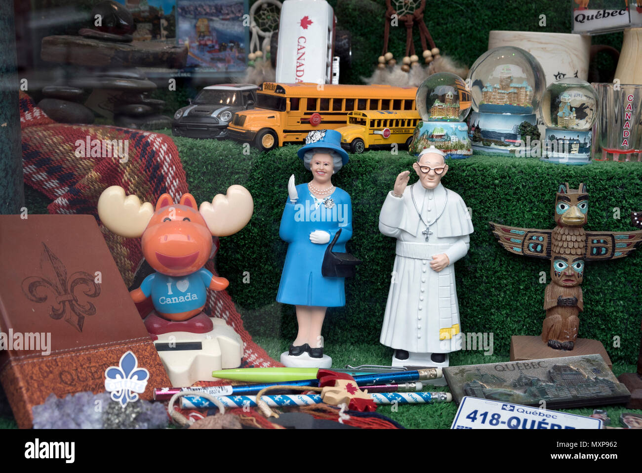 Quebec City, Kanada. Souvenirs in einem Schaufenster, darunter ein Elch, die Queen, der Papst und einen gelben Schulbus. Stockfoto