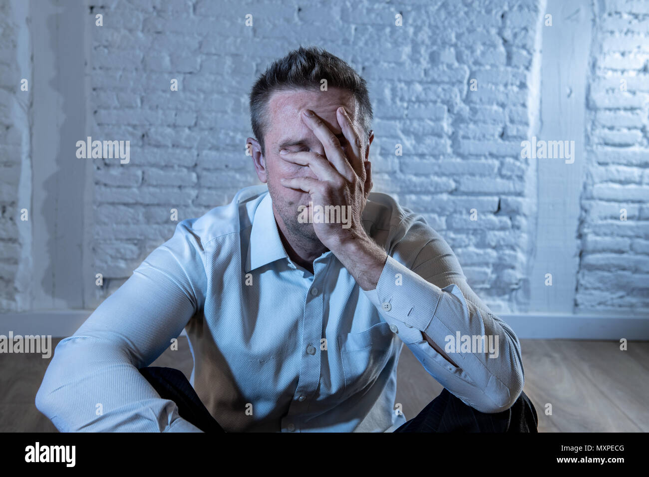 Deprimiert business Mann traurig, einsam und leiden unter Angst, lehnte sich auf eine weisse Wand zu Hause in der psychischen Gesundheit depression Konzept Stockfoto