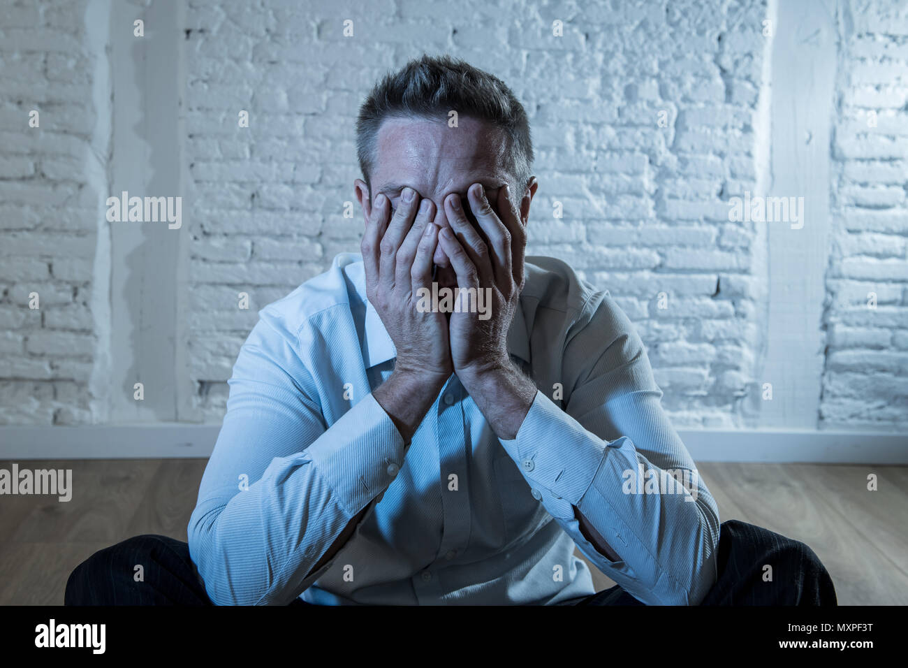 Deprimiert business Mann traurig, einsam und leiden unter Angst, lehnte sich auf eine weisse Wand zu Hause in der psychischen Gesundheit depression Konzept Stockfoto