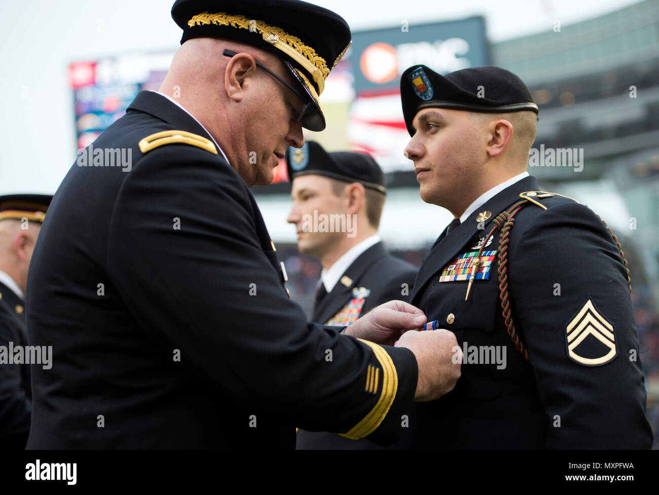 Illinois Army National Guard Staff Sgt. Jeremy Adkins (rechts), von Chicago, erhält die Soldaten Medaille von Brig. Gen. Michael Zerbonia, stellvertretender Adjutant General-Army der Illinois National Guard und Kommandant der Oklahoma Army National Guard, während die Chicago Bears alute Service" Spiel, Nov. 27 an Soldier Field, in Chicago. Adkins wurde für seine Tapferkeit im ziehen einen Treiber von einem brennenden Fahrzeug nach einem Unfall am 11. Mai 2016 anerkannt. (U.S. Army National Guard Foto von 1 Lt Aaron Ritter, Illinois National Guard Public Affairs) Stockfoto