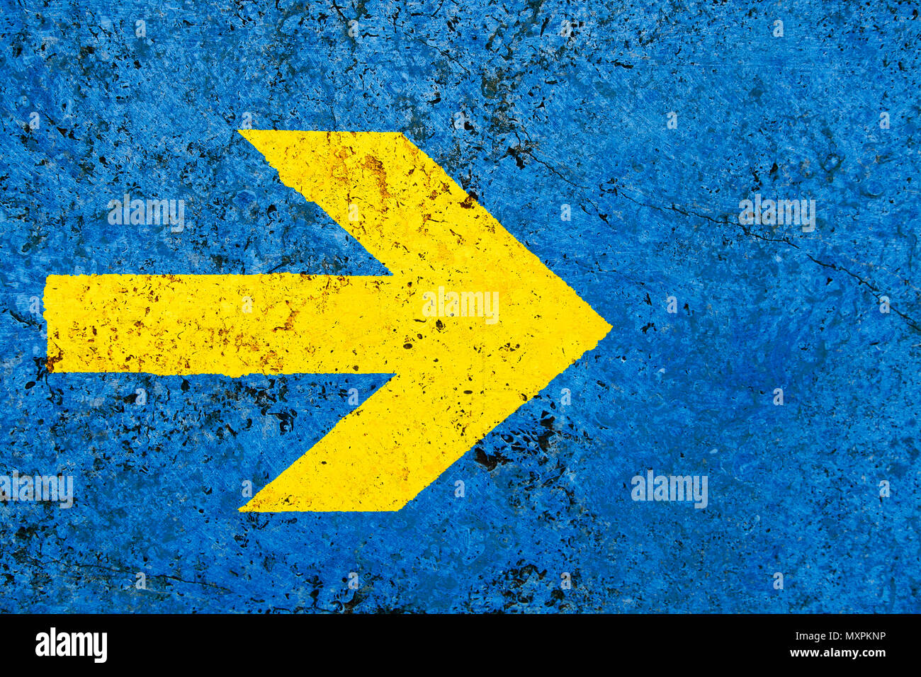 Gelber Pfeil Richtung Schild über lebendige helle blaue Farbe stone wall mit Unebenheiten und Risse als leere rustikal und einfach Hintergrund Textur spa Stockfoto
