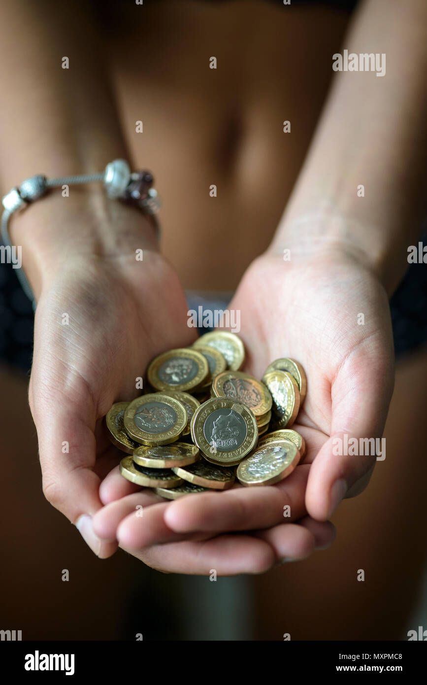 Hände voll mit britischen Pfund Münzen Stockfoto